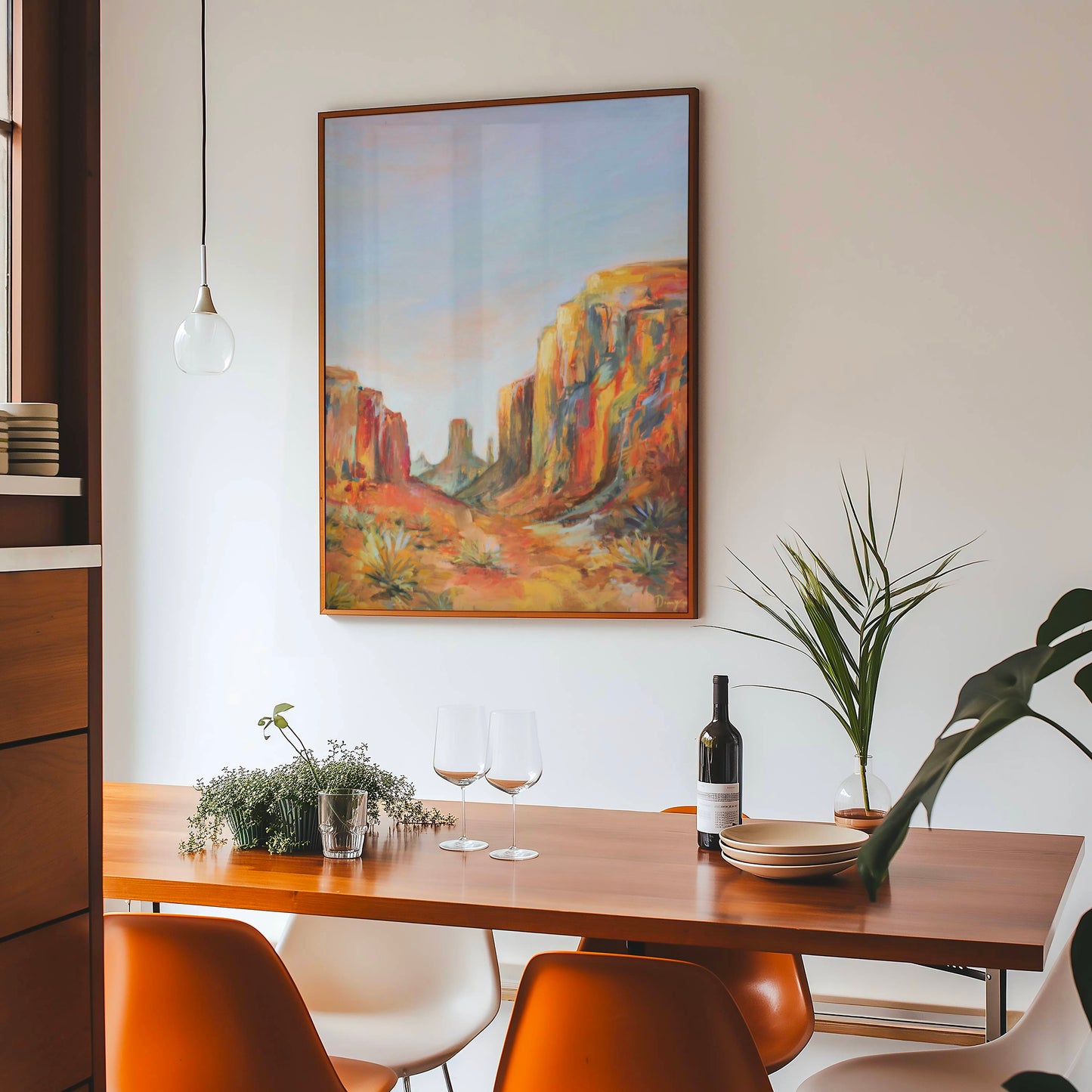 Dining room with a wooden table, chairs, and a large Arizona desert landscape painting on the wall.