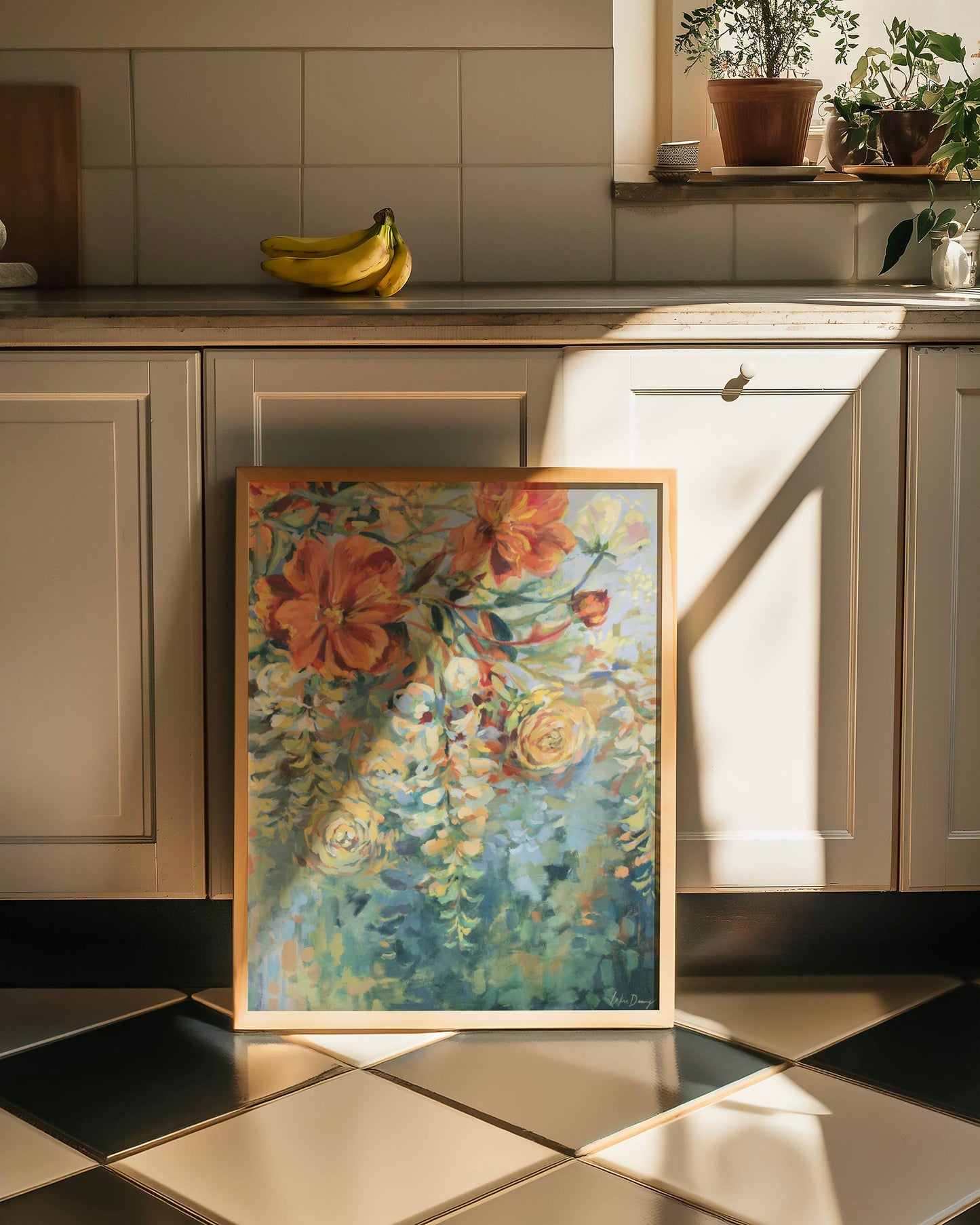Floral painting on a kitchen counter with cabinets and a tiled wall in the background.