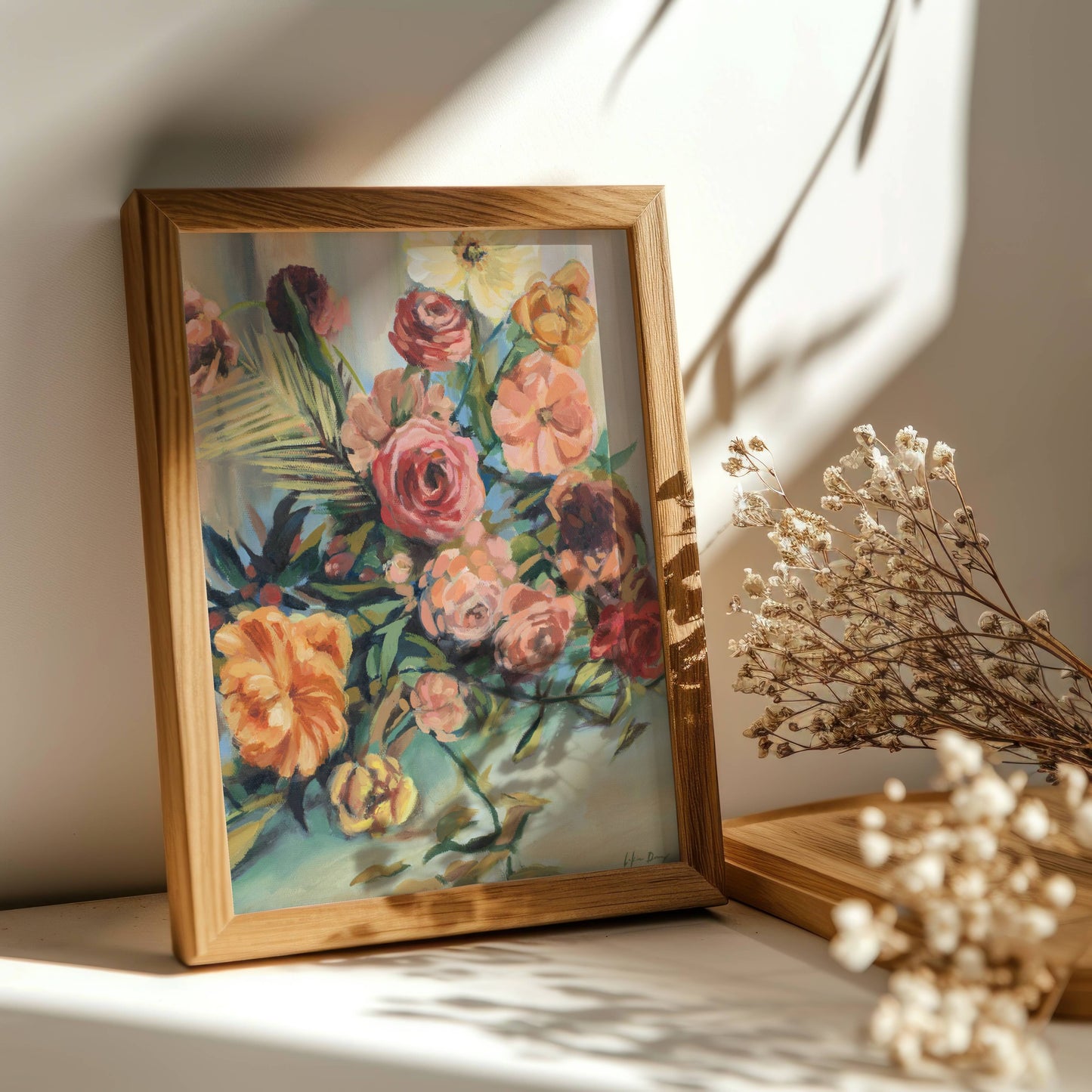 Framed colorful still life floral artwork on a surface with dried flowers.