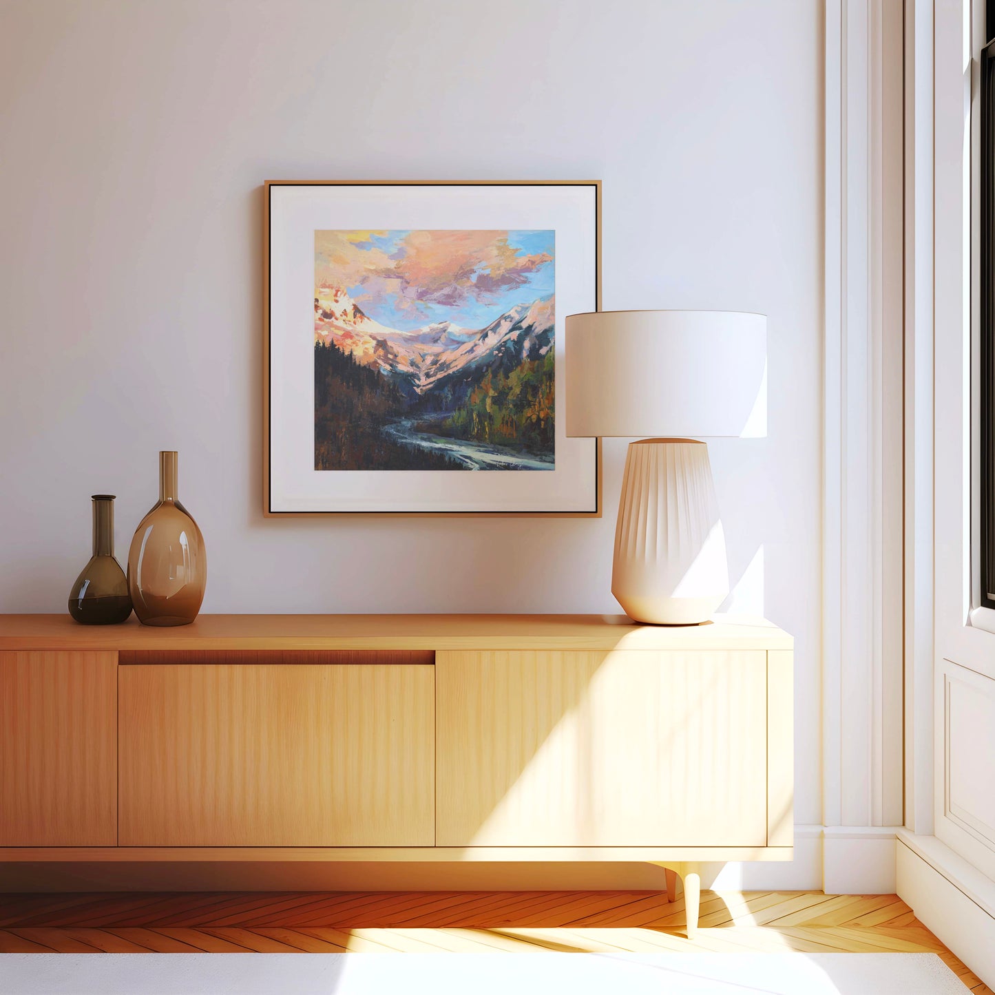 Modern interior with wooden cabinet, lamp, and framed mountain landscape painting.