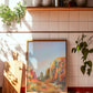 Framed Arizona southwestern desert landscape painting on a tiled wall with plants and a cutting board.