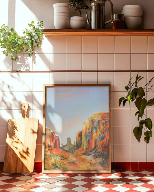 Framed Arizona southwestern desert landscape painting on a tiled wall with plants and a cutting board.