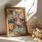 Framed colorful still life floral artwork on a surface with dried flowers.