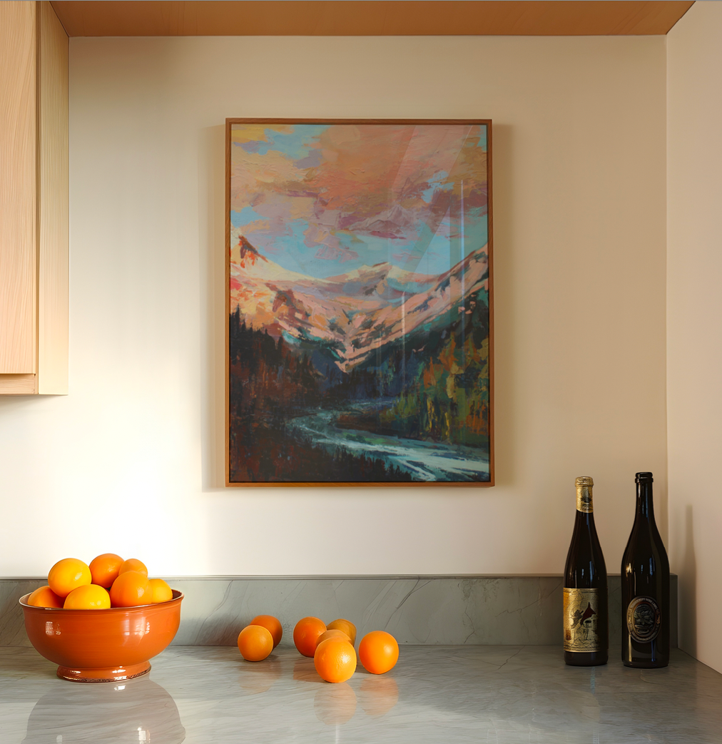 Kitchen counter with a bowl of oranges, scattered oranges, and wine bottles, with a mountain painting on the wall.