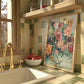 Kitchen counter with a sink, gold faucet, bowl of apples, and colorful floral painting on a tiled wall.