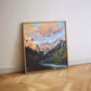 Framed painting of a mountain landscape on a wall with wooden flooring.