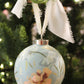 Decorative Christmas ornament with floral design hanging on a tree