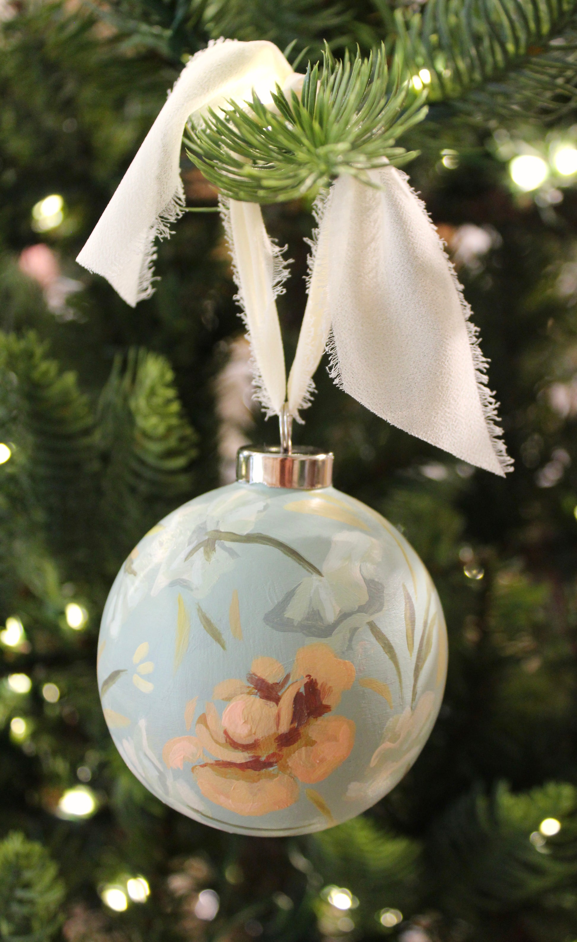 Decorative Christmas ornament with floral design hanging on a tree